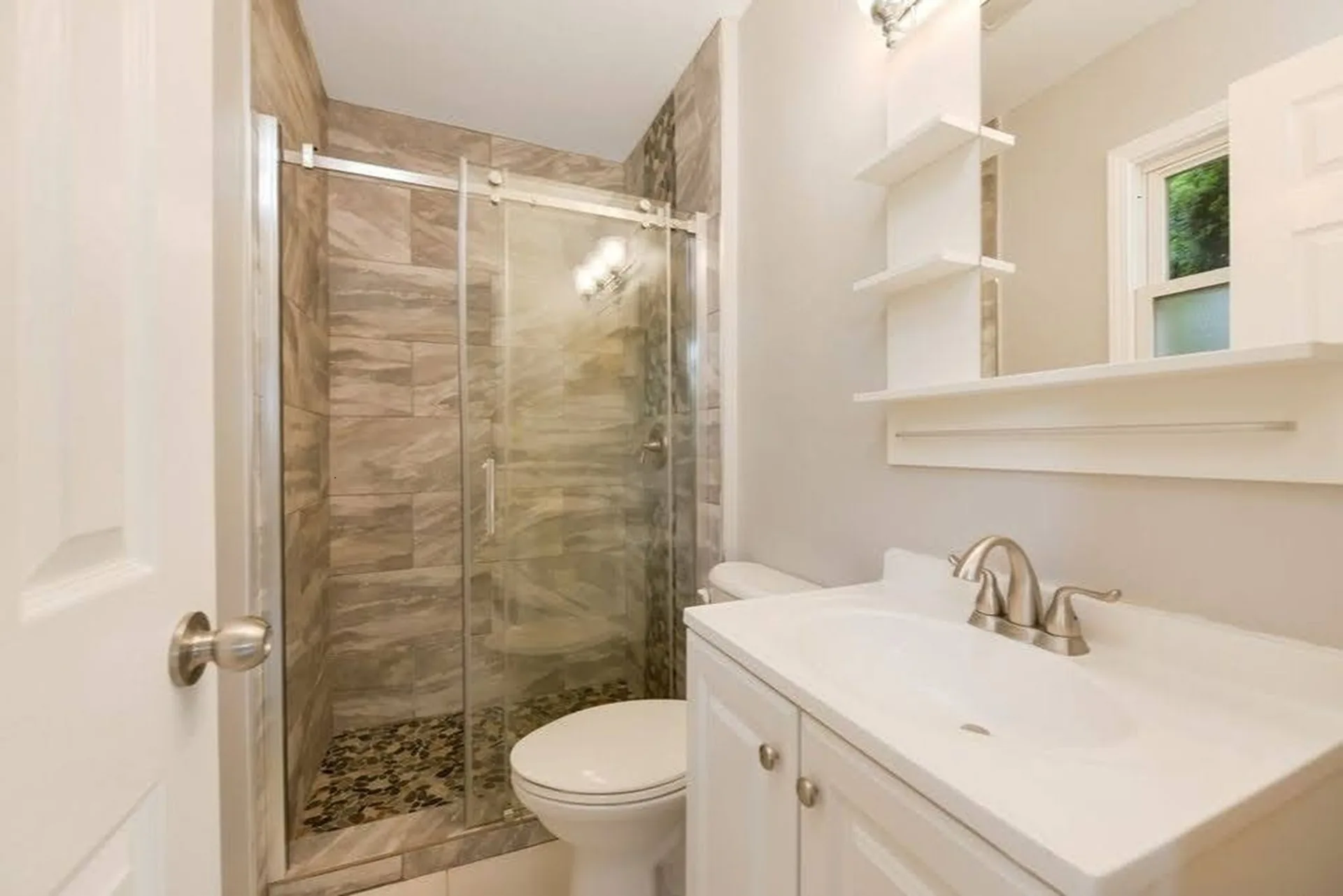 Bathroom with marble vanity and exposed brick