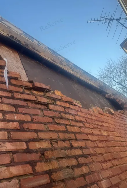 Before: Brick parapet: damaged section, then the rebuild in progress.