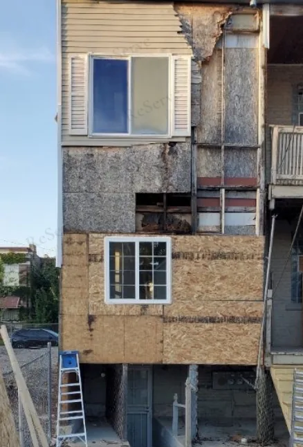 Before: Exterior wall rebuild in progress: damaged sheathing replaced, new siding going on.